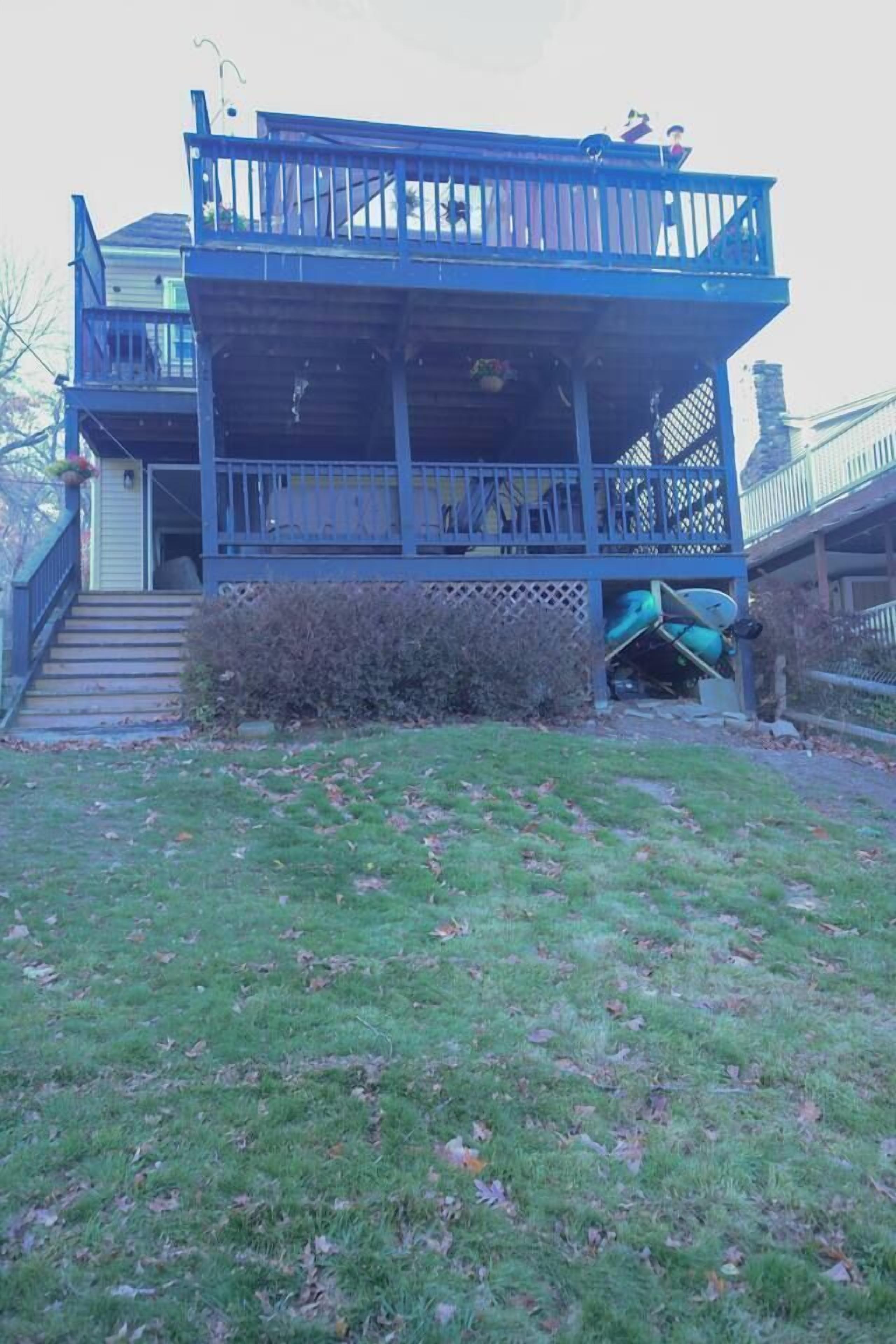 A two-story house with a balcony, a front porch, and a staircase leading to the entrance.
