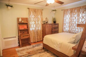 A bedroom with a bed, wooden dresser, and a ceiling fan. - Lakehaven • Hot Tub, Decks, Fires & More (Plymouth)