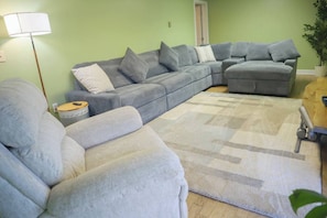 A living room with a sectional sofa, a small side table, and a floor lamp.