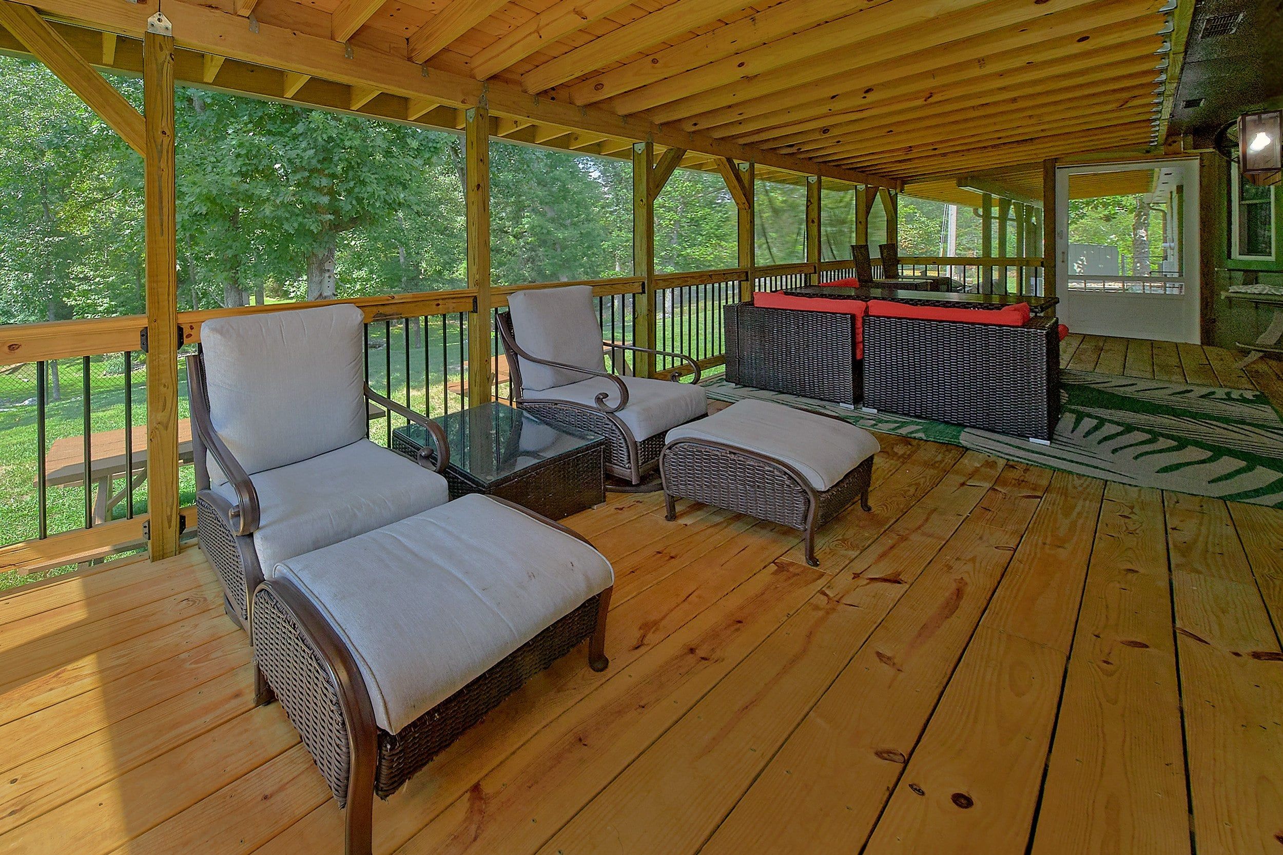 A covered outdoor seating area with wicker furniture and a glass-top table.