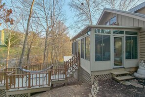 Une cabane dotée d’un porche abrité, d’un hamac et offrant une vue sur les arbres environnants.