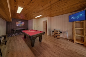 A pool table in a room with wooden walls and ceiling, a neon sign, and a television on the wall. - Hidden Escape | Hot Tub, Game Room, Fire Pit, Resort Pool, Fireplace + Free Attraction Tickets (Sevierville)