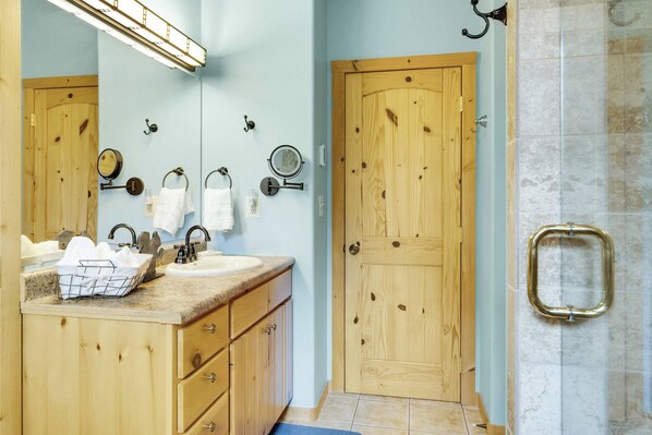Une salle de bain avec un meuble-lavabo en bois, un évier, un miroir et un porte-serviettes.
