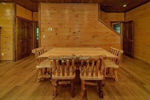 A wooden interior with a central table and chairs made from logs, surrounded by wooden walls and floors. - Smoky Mountain Splash | Private Pool, Theater, Hot Tub, Game Room + Free Attraction Tickets (Sevierville)
