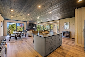 A spacious kitchen with a large island, wooden flooring, and a modern ceiling design. - Ski Mountain Swim | Private Pool, Mtn Views, Hot Tub, Game Room, Sleeps 10 + Free Attraction Tickets (Gatlinburg)