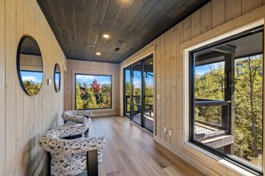 A modern interior with wooden walls, a ceiling with recessed lighting, and large windows offering views of trees and a mountain. - Ski Mountain Swim | Private Pool, Mtn Views, Hot Tub, Game Room, Sleeps 10 + Free Attraction Tickets (Gatlinburg)