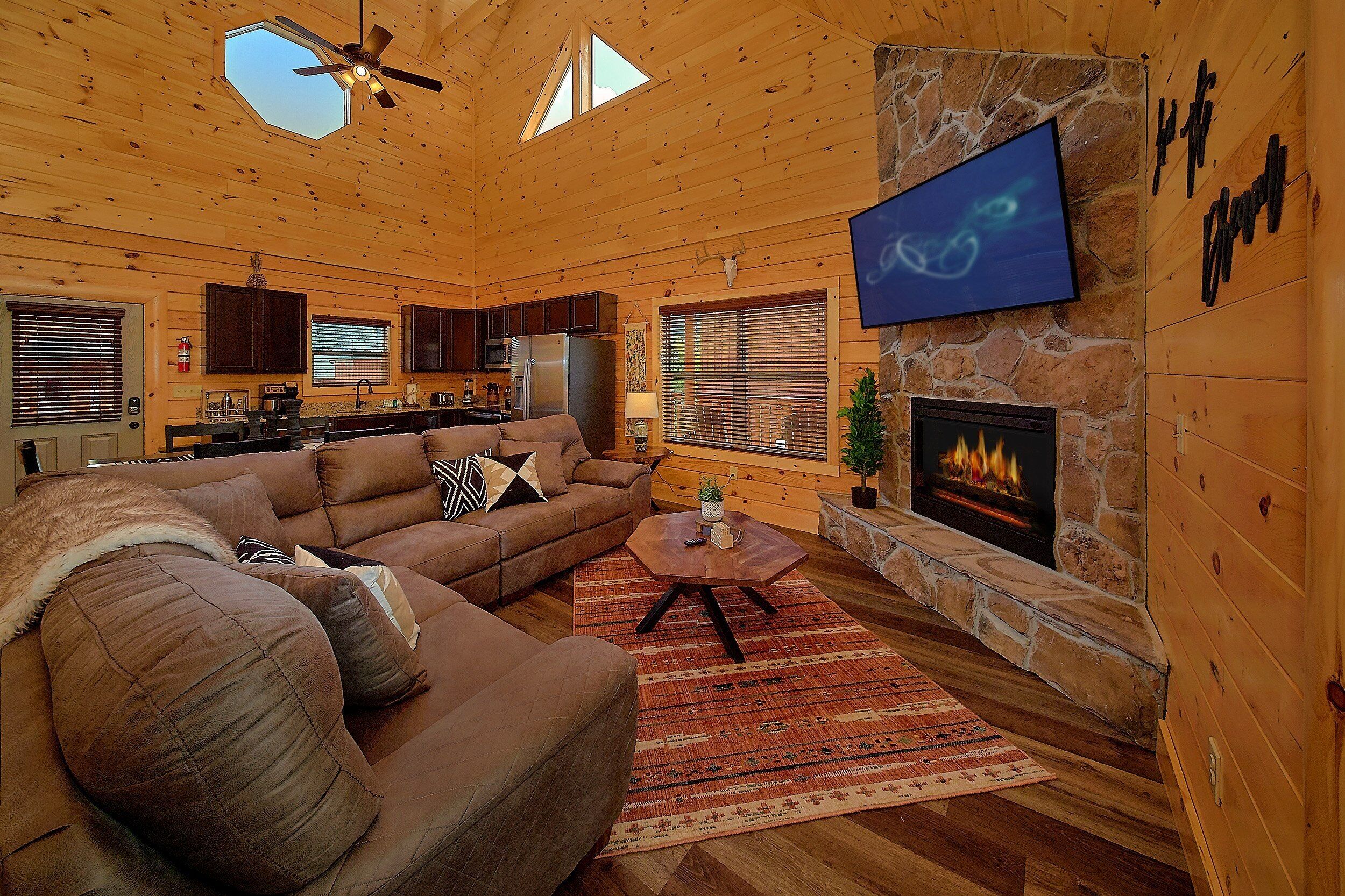 Interior acogedor de una cabaña de madera con sala de estar, cocina y chimenea.