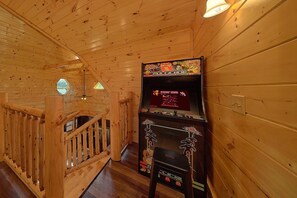 A wooden interior with a Nintendo gaming console displaying 'Donkey Kong' and 'Multicade' on the screen. - Livin' the Dream | Private Pool, Hot Tub, Game Room, Sleeps 12, Fireplace + Free Attraction Tickets (Pigeon Forge)