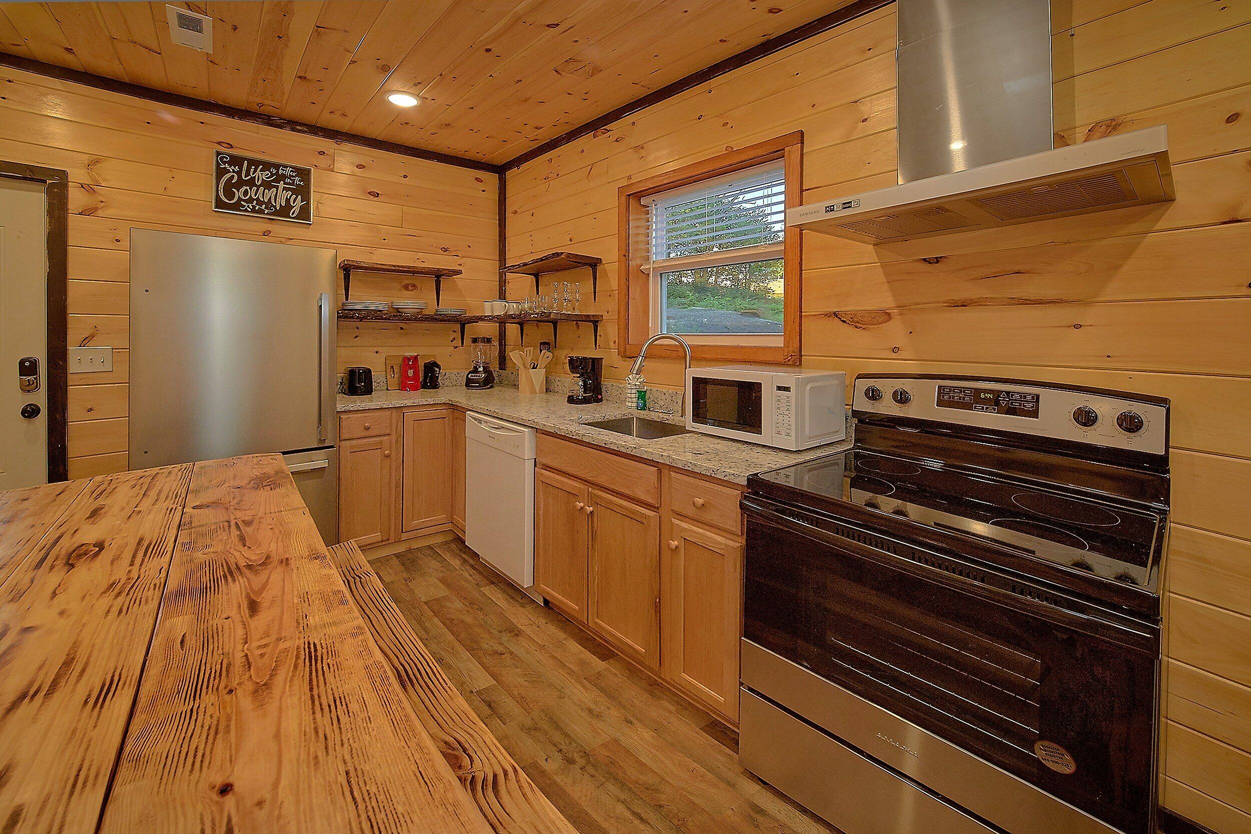 A kitchen with wooden cabinets, a stainless steel refrigerator, a microwave, a dishwasher, and a stove.