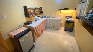 Una cocina compacta con refrigerador, pileta y estufa.
