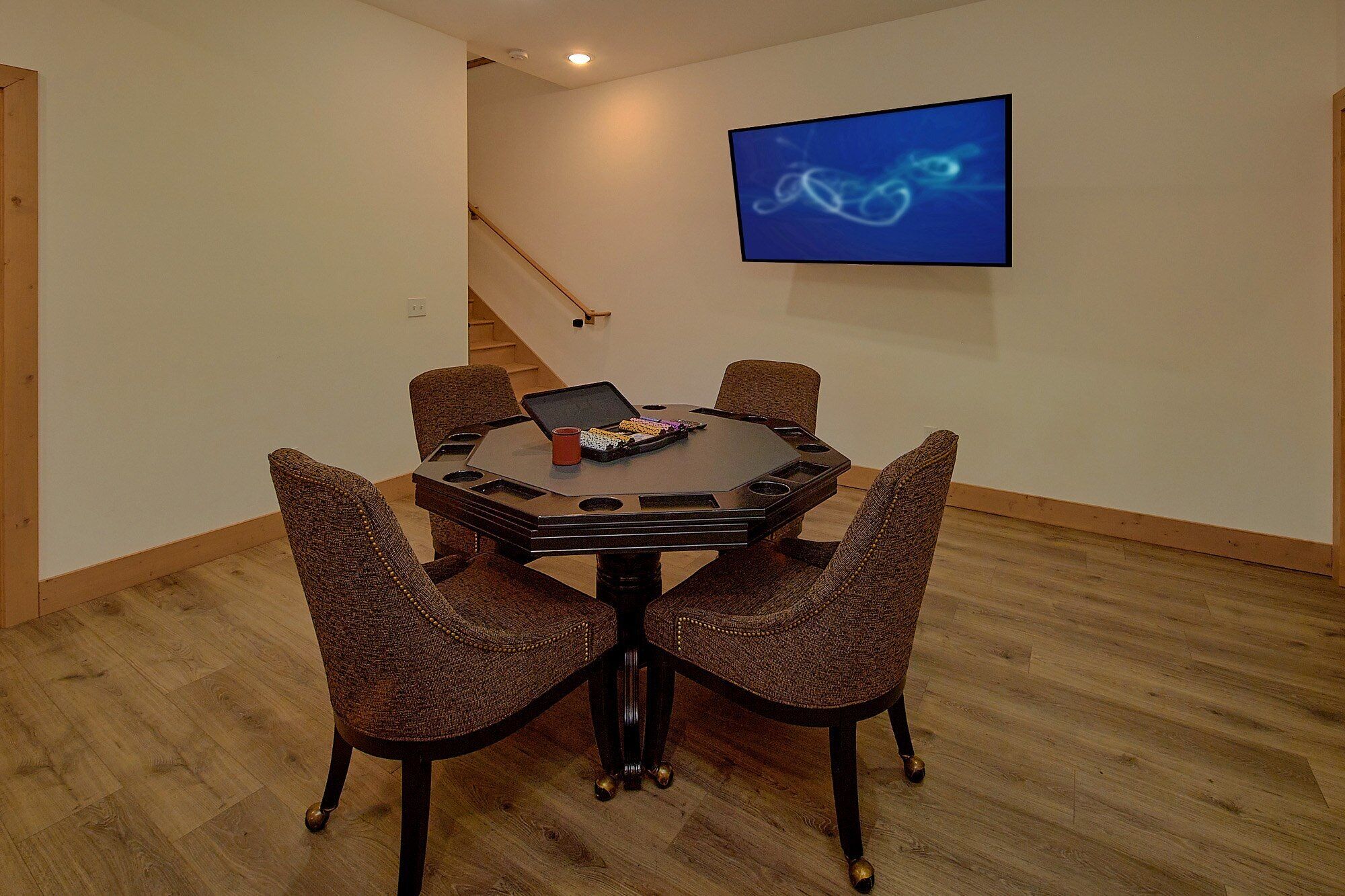 Een vergaderzaal met een ronde tafel, zes stoelen, een laptop en een decoratief object op tafel.