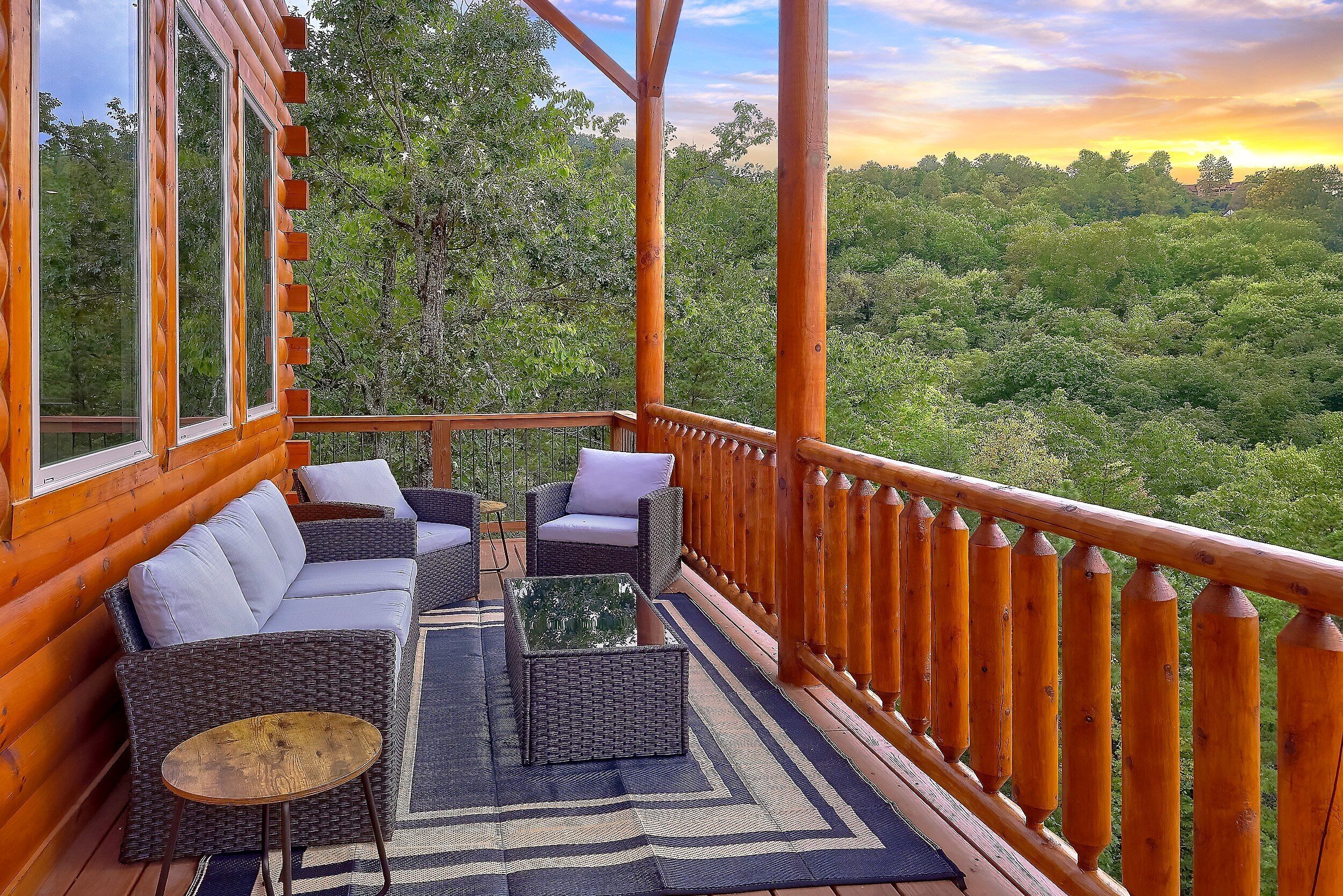 A wooden deck with wicker furniture and a view of a forest.