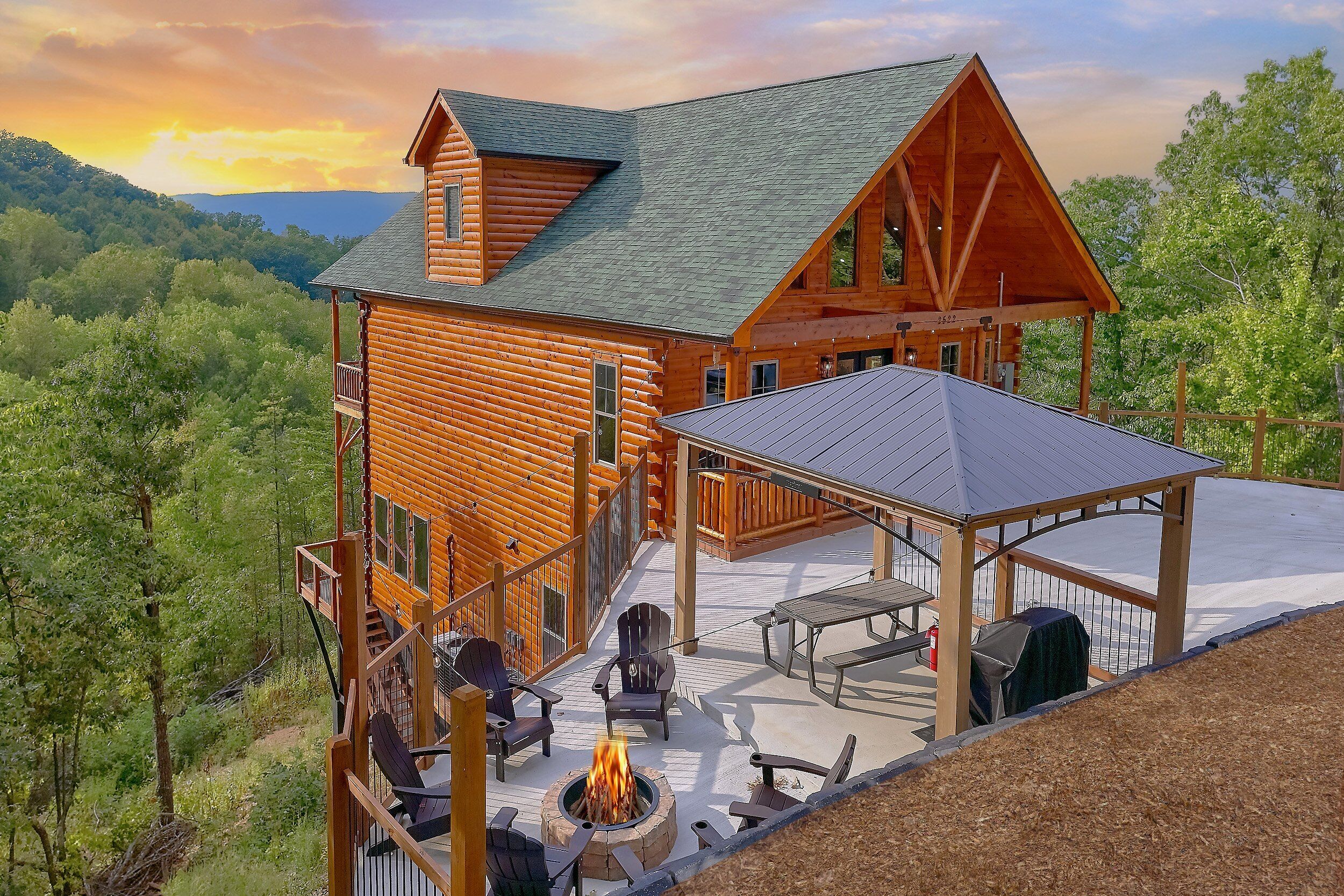 A log cabin with a deck, outdoor seating, and a fire pit.