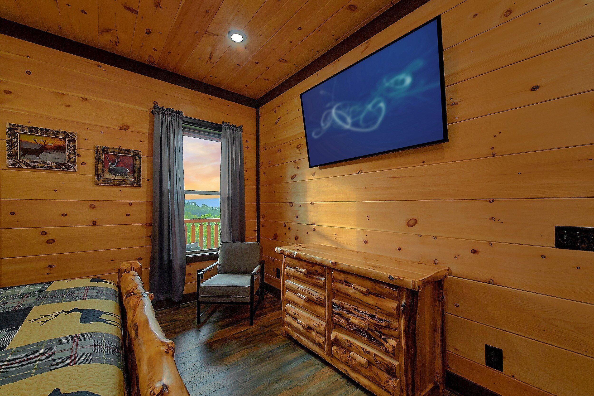A room with wooden walls, a bed, a chair, a dresser, and a television.