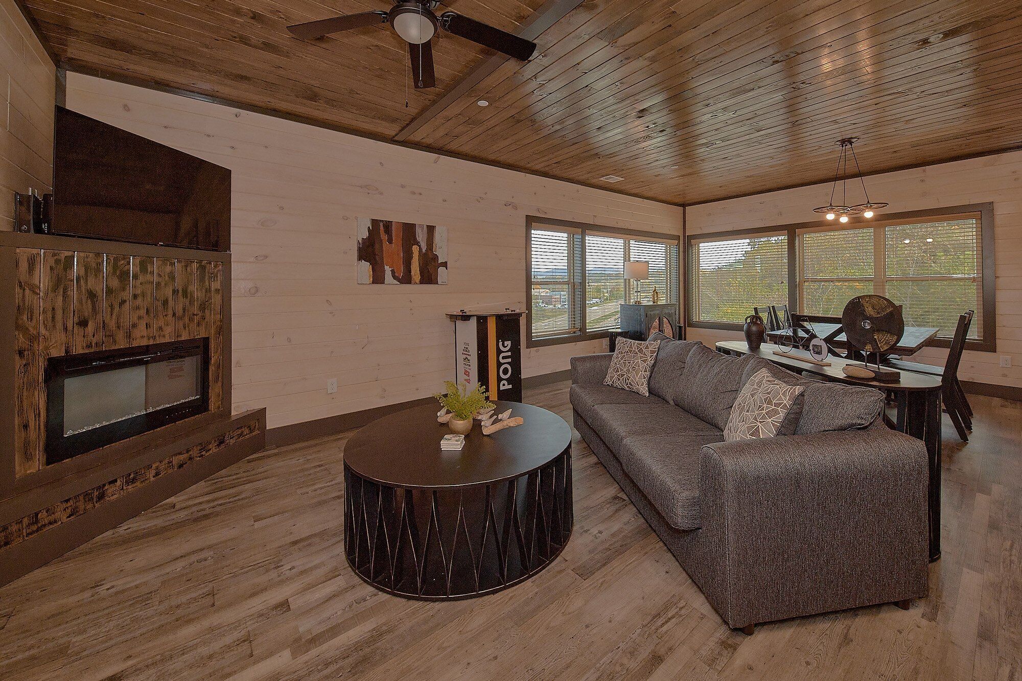 A living room with a fireplace, a sofa, a coffee table, and a dining area with a table and chairs.