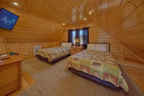A cozy attic bedroom with two beds, a TV, and a window with curtains. - A Glimpse of Heaven | Sweeping Mountain Views | Hot Tub (Sevierville)