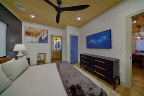 A bedroom with a bed, a dresser, a ceiling fan, and artwork on the walls. - Downtown Gatlinburg Cabin | Hot Tub, Near Downtown Gatlinburg, Game Room + Free Attraction Tickets (Gatlinburg)