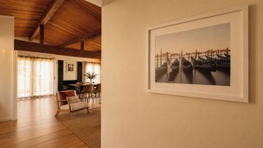 Ein Zimmer mit Holzboden, einem Essbereich mit Tisch und Stühlen sowie einem gerahmten Bild an der Wand.