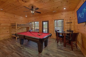A wooden interior with a pool table, a ceiling fan, and a billiards rack. - Lazy Bear Lodge | Hot Tub, Game Room, Resort Pool + Free Attraction Tickets (Sevierville)
