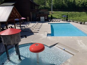 A swimming pool with lounge chairs and a water feature. - Lazy Bear Lodge | Hot Tub, Game Room, Resort Pool + Free Attraction Tickets (Sevierville)