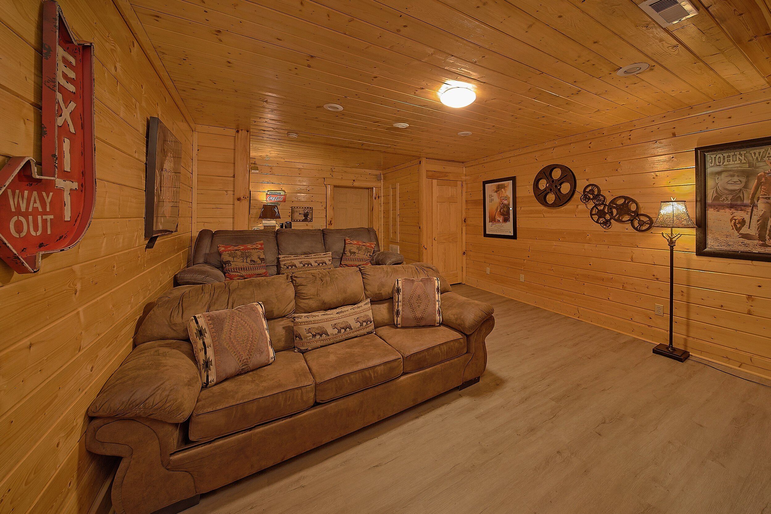 Ein gemütliches Blockhaus-Interieur mit einer Couch, Wanddekorationen und einer Holzbalkendecke.