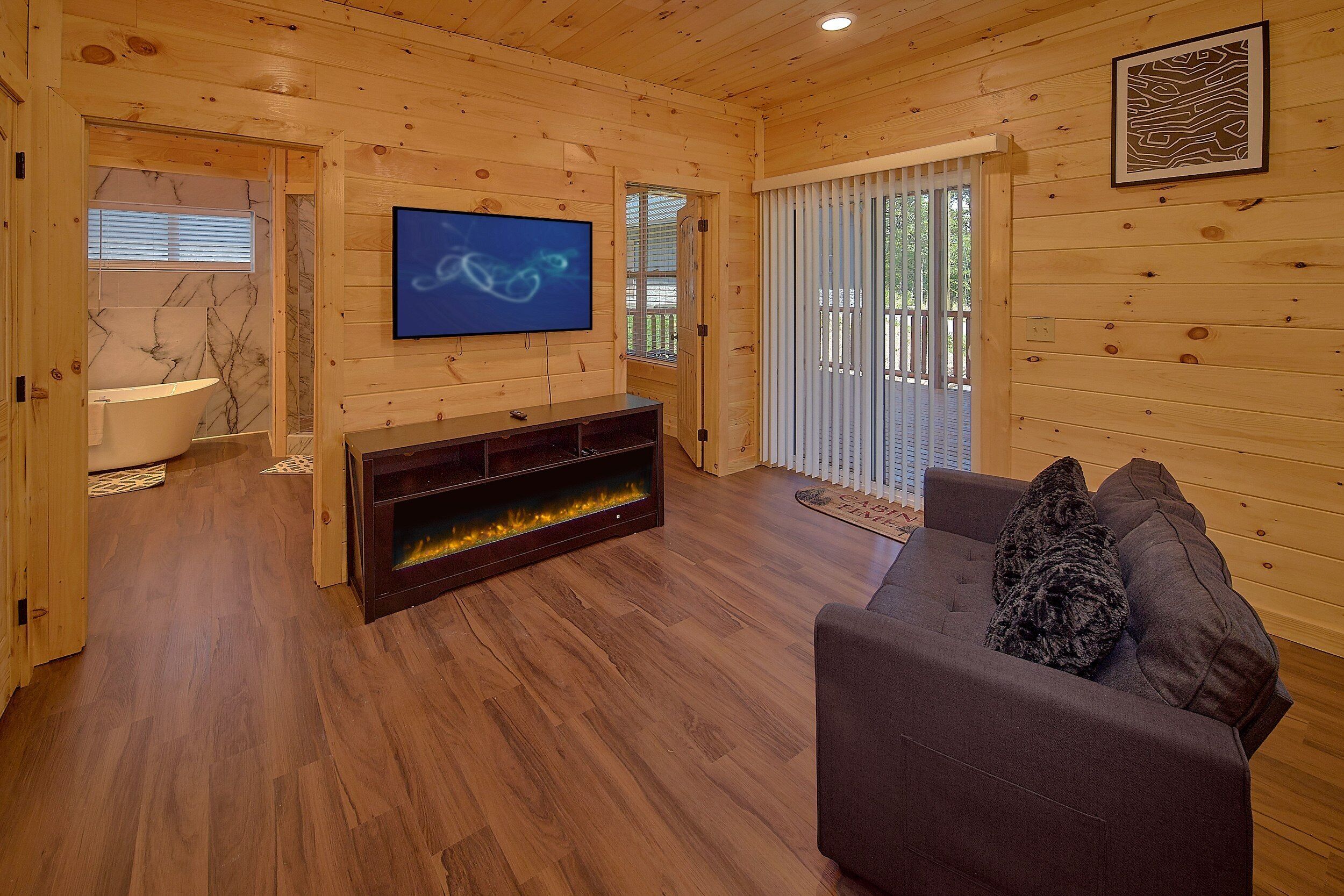 A wooden interior with a fireplace, a television, and a sofa.
