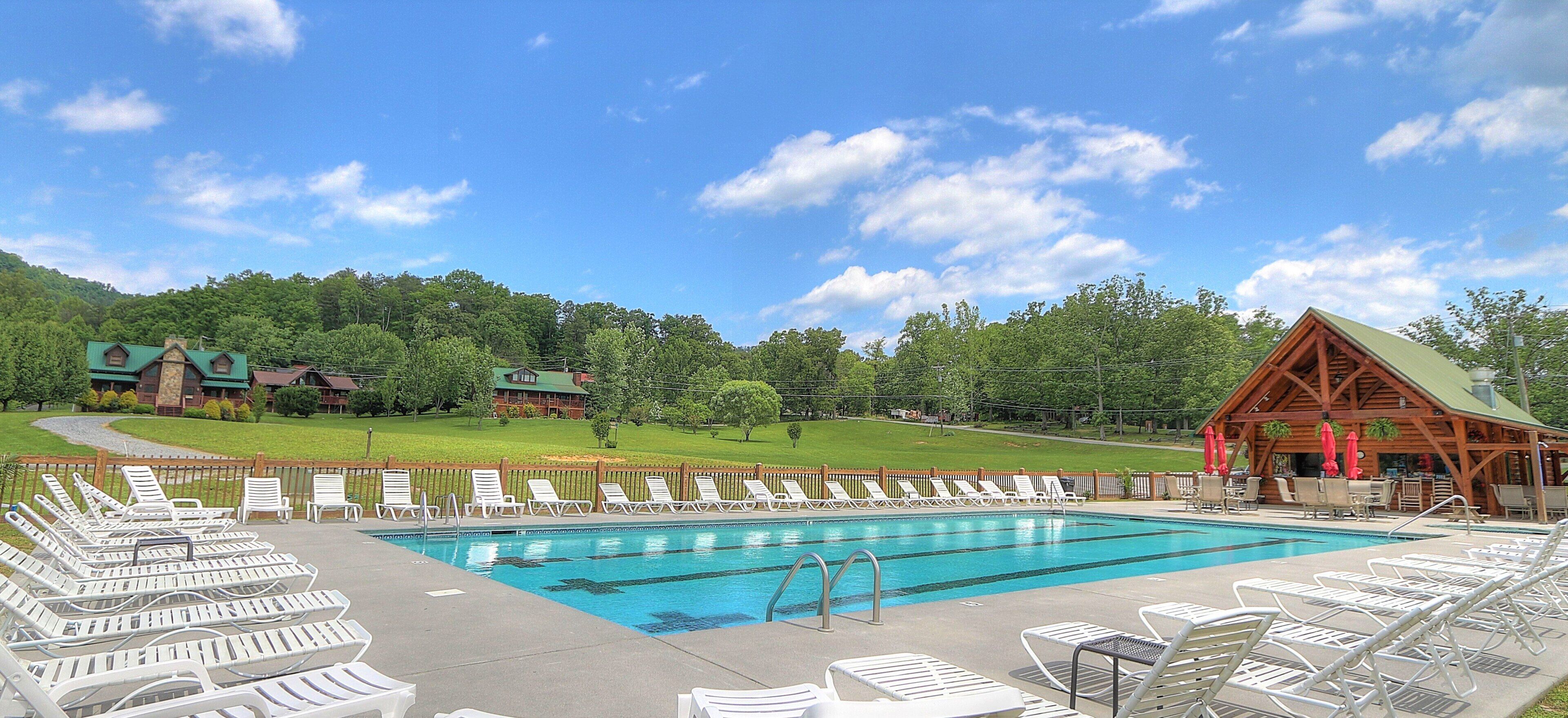 A swimming pool with lounge chairs and a wooden pavilion.