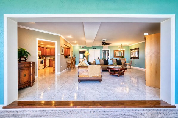A spacious living area with a sofa, coffee table, and a dining area with chairs and a table.