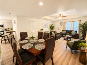 A modern living room with a dining area, a kitchen, and a ceiling fan. - 
The Perfect Getaway: 2BR Luxury Retreat (Harker Heights)