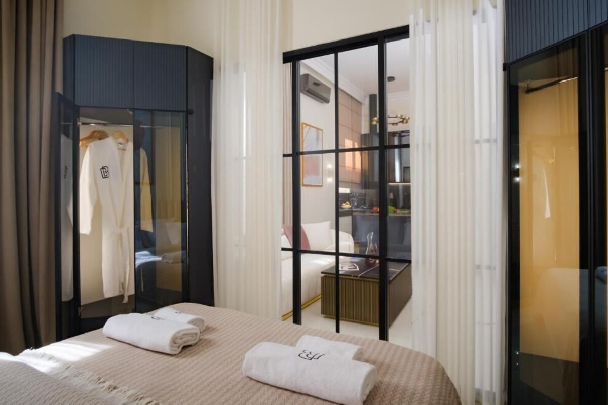 Ein Hotelzimmer mit Bett, Schrank, Spiegel und Blick zur Küche.