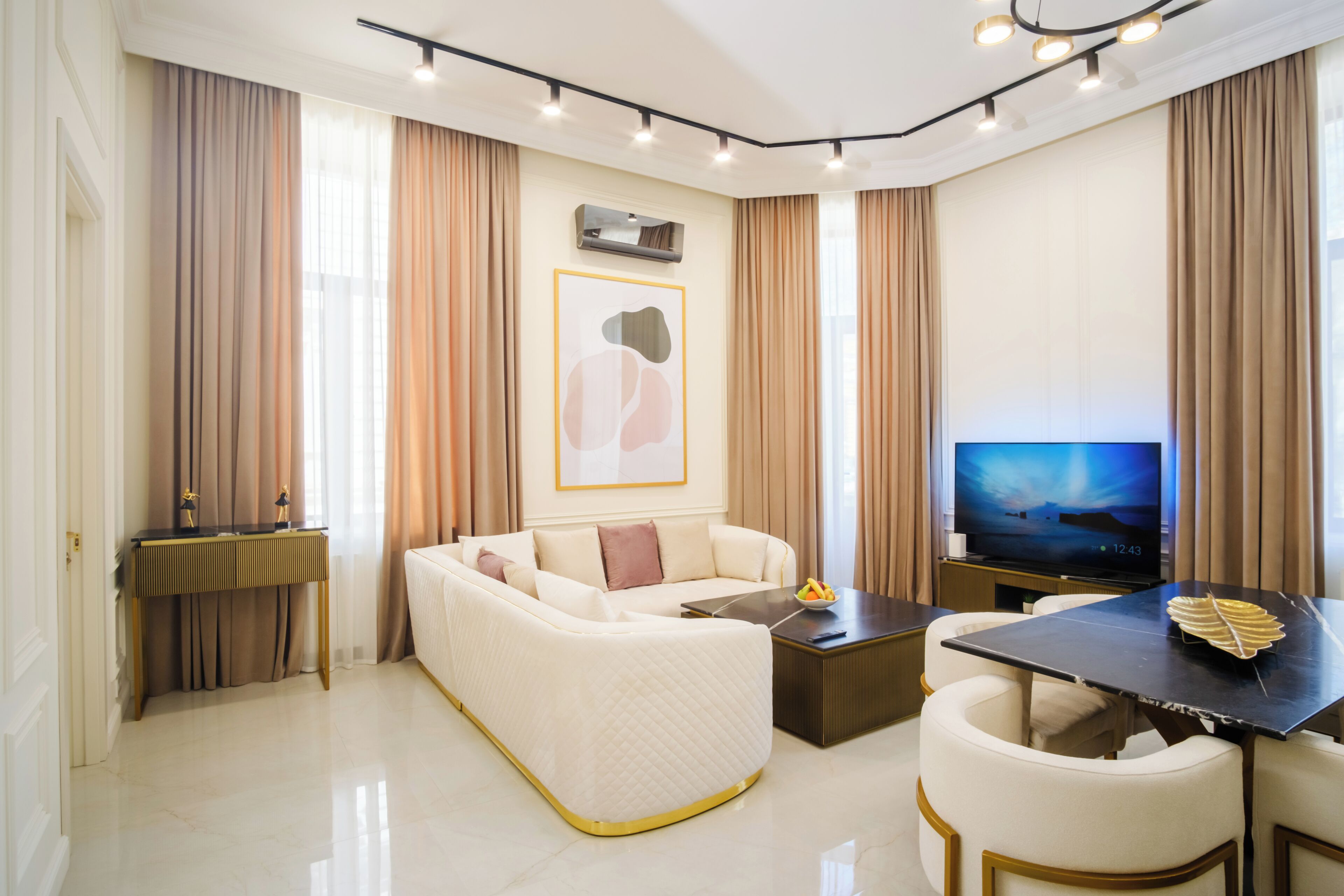 Uma sala de estar moderna com sofá, mesa de centro, televisão e espaço para refeições.