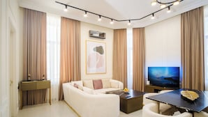 Un saló modern amb un sofà, una taula de centre, una televisió i una zona de menjador.