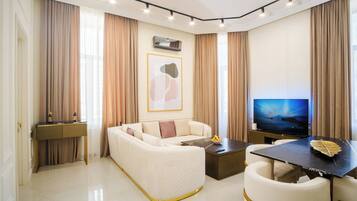Uma sala de estar moderna com sofá, mesa de centro, televisão e espaço para refeições.