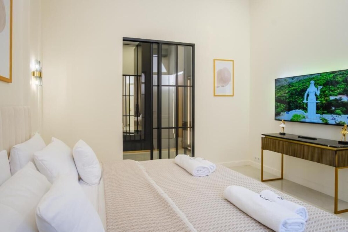 Ein Hotelzimmer mit Bett, Fernseher und Schreibtisch.