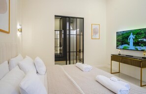 Ein Hotelzimmer mit Bett, Fernseher und Schreibtisch.