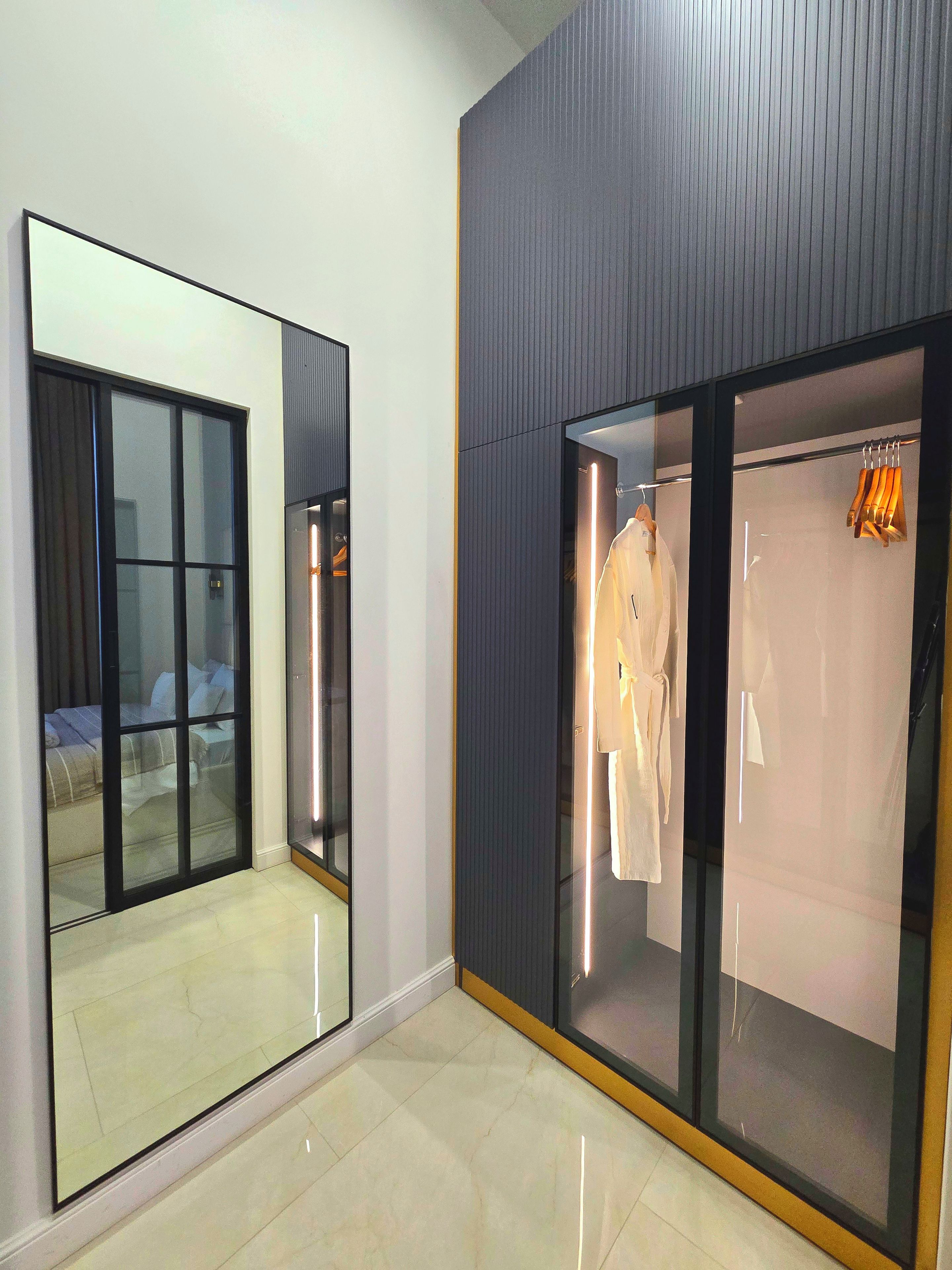 A hotel room with a large mirror, a sliding glass door closet, and a bed with a view of the outside.