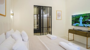 Habitació d'hotel amb un llit, televisió, escriptori i vista a una estàtua.