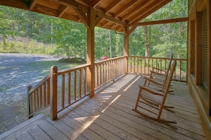 A wooden deck with a railing, overlooking a gravel area and a forested landscape. - Moose Tracks | Mtn Views, Game Room, Resort Pool, Pet Friendly, Fireplace + Free Attraction Tickets (Wears Valley)