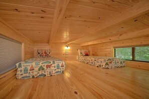 A cabin with two beds, a fireplace, and a large window. - A Camper's Delight | Pet-Friendly Tiny Home w/ Fire Pit (Wears Valley)