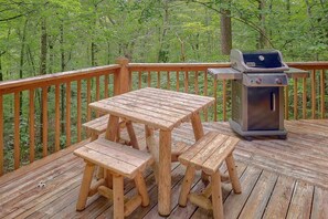 Eine Holzterrasse mit Grill und Picknicktisch.