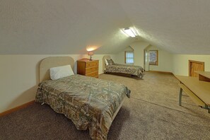 A bedroom with two beds, a dresser, a desk, and a ceiling light. - Misty Cove Cabin Rental (Wears Valley)