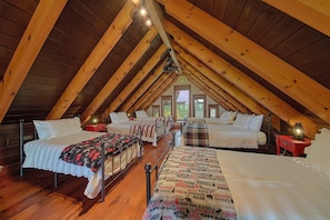 A cozy attic bedroom with wooden beams, two beds, and a view of the outdoors. - Grouse Ridge Lodge | Smoky Mtn Views, Hot Tub, Sleeps 12, Fire Pit + Free Attraction Tickets (Wears Valley)