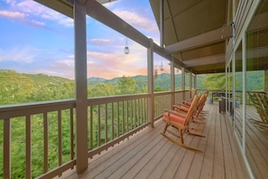 A wooden deck with a view of a forested landscape. - Almost Heaven II Cabin Rental (Wears Valley)