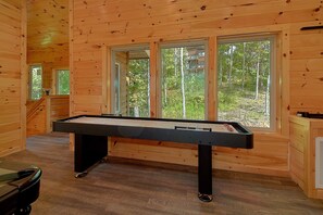 A pool table in a wooden room with large windows. - Big Bad John's Cabin Rental (Wears Valley)