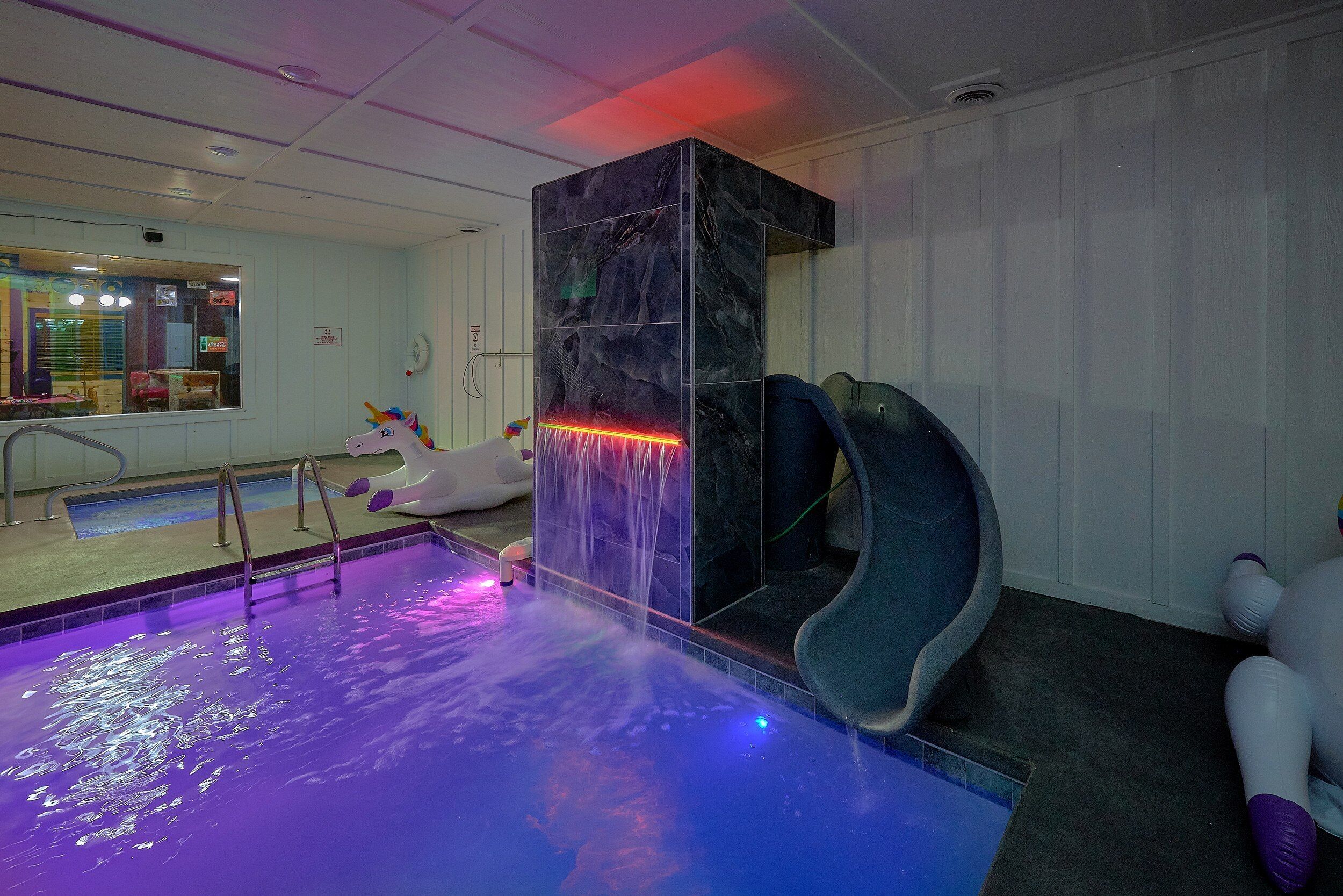 A pool area with a slide, a unicorn decoration, and a Coca-Cola sign.