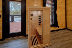 A room with a wooden door, a window with blinds, and a view of a deck outside. - Amazing Mountain II Cabin Rental (Sevierville)