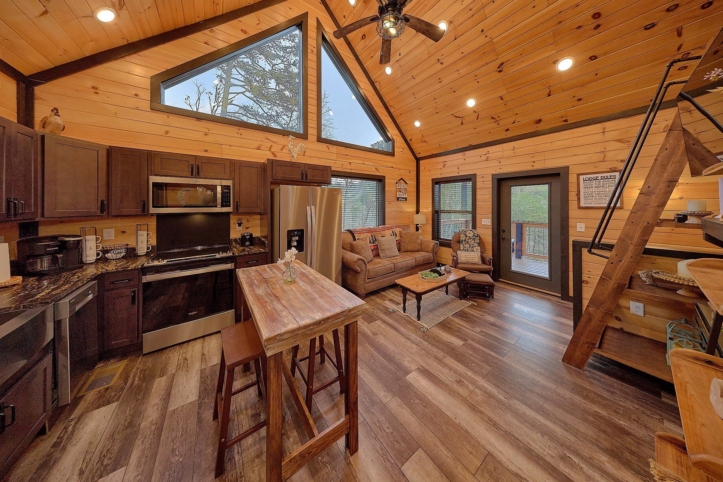 A cabin interior with a kitchen, dining area, and living room.