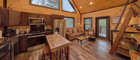 A cabin interior with a kitchen, dining area, and living room.