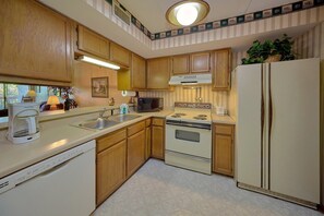 A kitchen with wooden cabinets, a stove, a refrigerator, and a microwave. - Our Mountain Home | Smoky Mtn Views, Gatlinburg, Fireplace + Free Attraction Tickets (Gatlinburg)