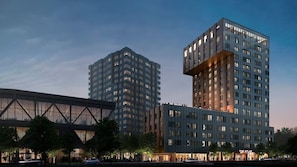 Ein modernes Hochhaus mit einem einzigartigen architektonischen Design, gekennzeichnet durch eine große Glasfassade und mehrere Balkone.